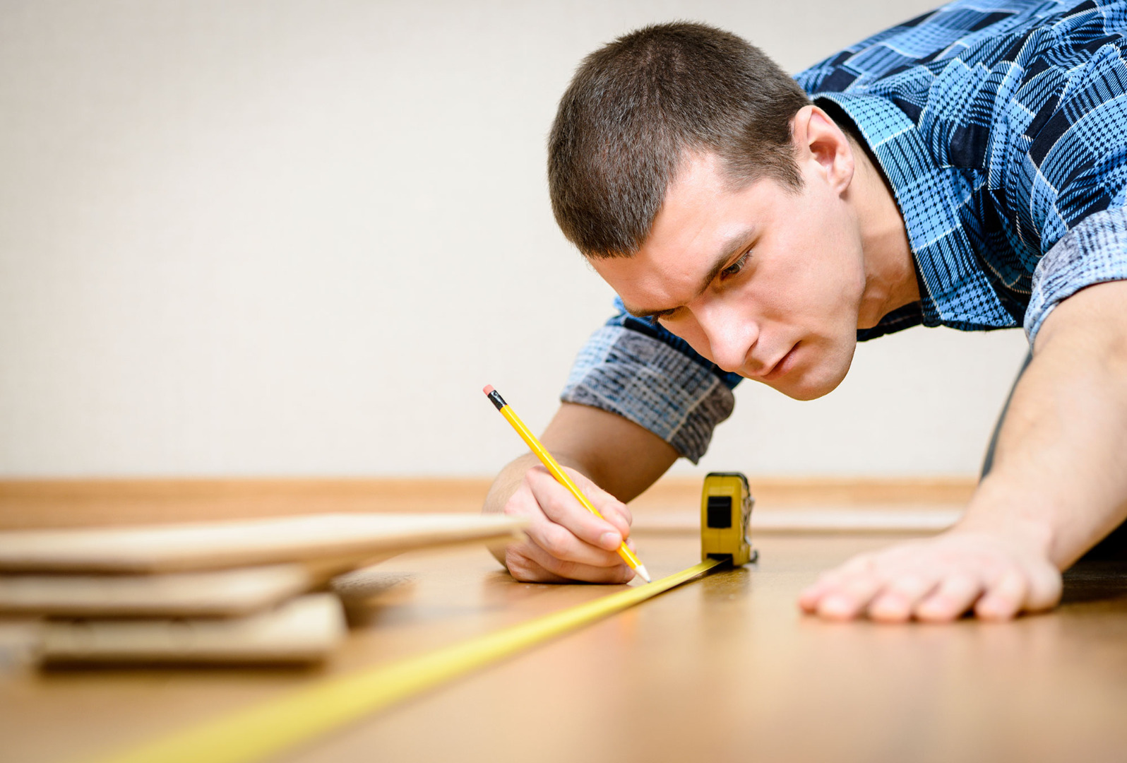 young contractor measuring flooring 